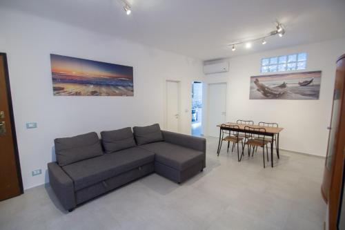 een woonkamer met een bank en een tafel bij Appartamento piazza Buccelli a 10 mt dal mare in Varazze