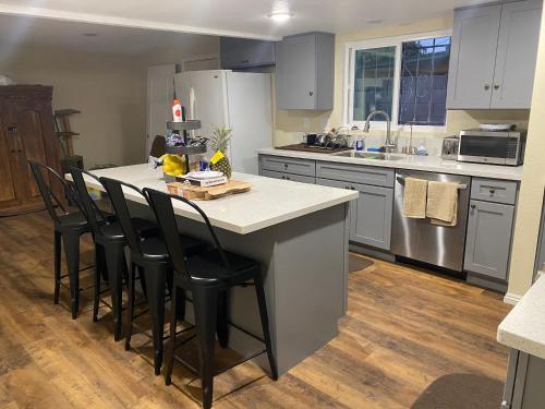 a kitchen with a large island with black chairs at Casa Tranquila in Santa Ana