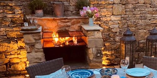 a stone patio with a table and a fireplace at Little Campden House in Chipping Campden