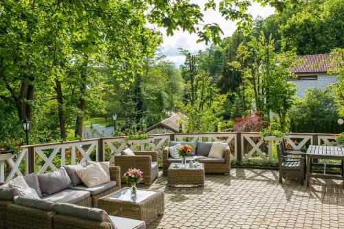 a patio with couches and tables and a fence at Berberys Park Hotel in Kazimierz Dolny