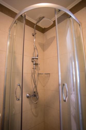 a shower with a glass door in a bathroom at Studios Artemis in Lefkada Town