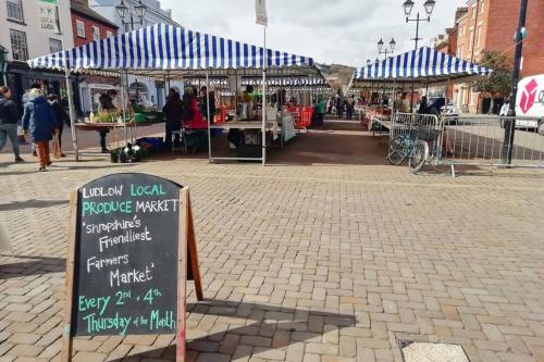 a market with a sign in the middle of a street at Cosy, elegant apartment in heart of Ludlow Town in Ludlow