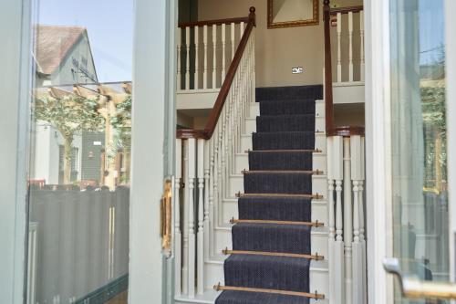 a staircase in a house with blue carpet at Beckford Inn in Beckford