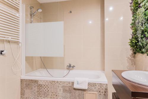 a bathroom with a tub and a sink at English Home in Silver Mountain Resort Poiana Brasov in Poiana Brasov