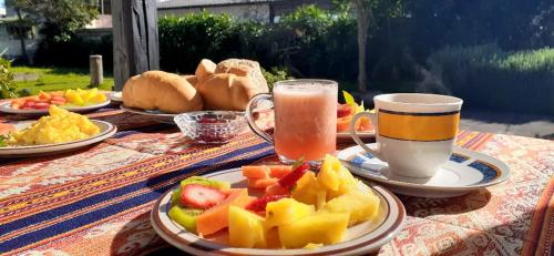 a table with plates of fruit and two cups of juice at Hostería Chíguac in Machachi