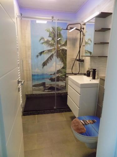 a bathroom with a shower with a painting of a beach at WOHLFÜHL Oase in Horumersiel