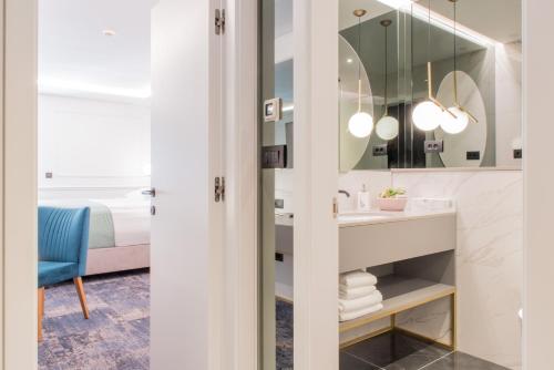 een badkamer met een wastafel en een spiegel bij Hotel Krilo in Podstrana