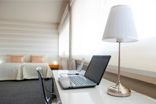 a laptop on a table in a room with a bed at Hotel Eurosol Leiria & Jardim in Leiria