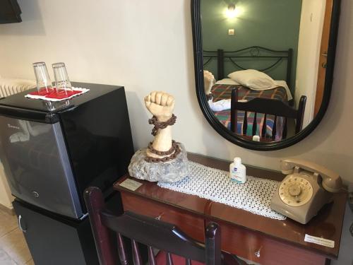 een televisie op een tafel met een spiegel bij Hotel George in Kalamata