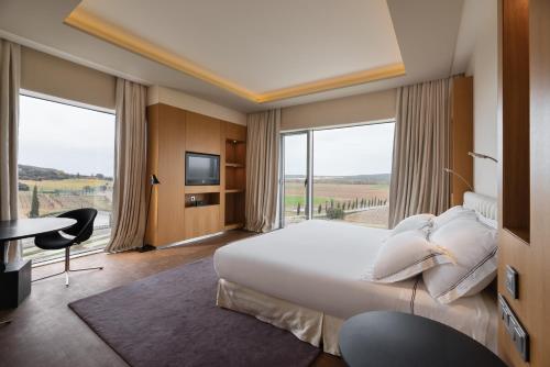a hotel room with a large bed and a large window at Valbusenda Hotel Bodega & Spa in Toro