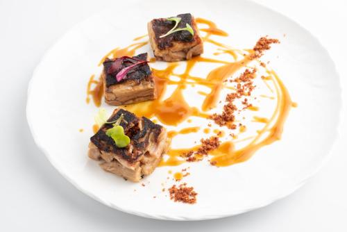 a white plate with three pieces of food on it at Valbusenda Hotel Bodega & Spa in Toro