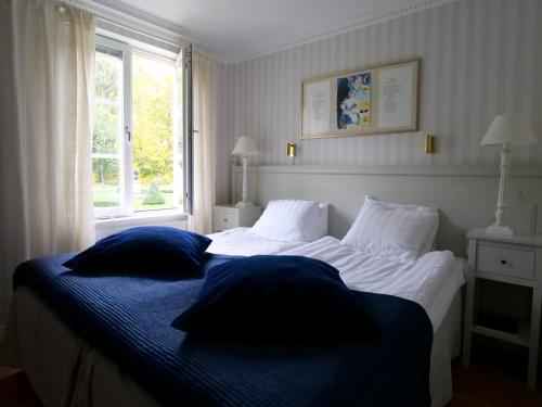a bedroom with a bed with two pillows and a window at Södertuna Slott in Gnesta