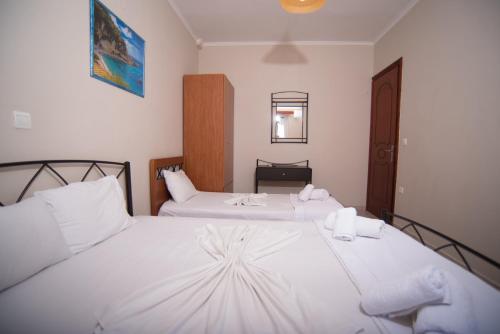 a bedroom with two beds with white sheets at Studios Artemis in Lefkada Town