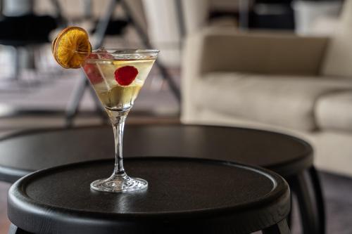 a drink with a strawberry and an orange on a table at Valbusenda Hotel Bodega & Spa in Toro