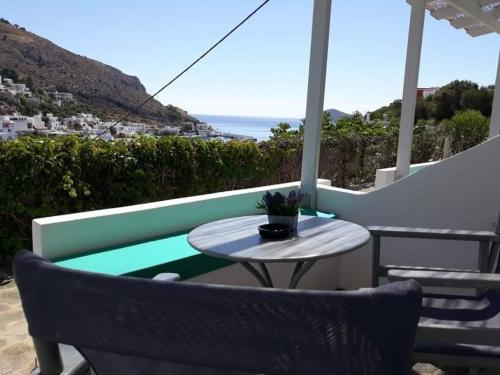 a table and chairs on a balcony with the ocean at STELLA MARINA in Panteli