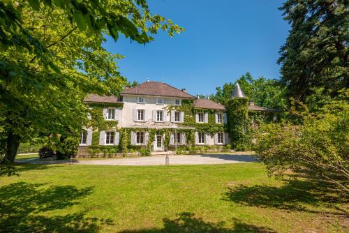 duży biały dom z dużym dziedzińcem w obiekcie Chateau des Ayes - Chambres & suites w mieście Saint-Étienne-de-Saint-Geoirs