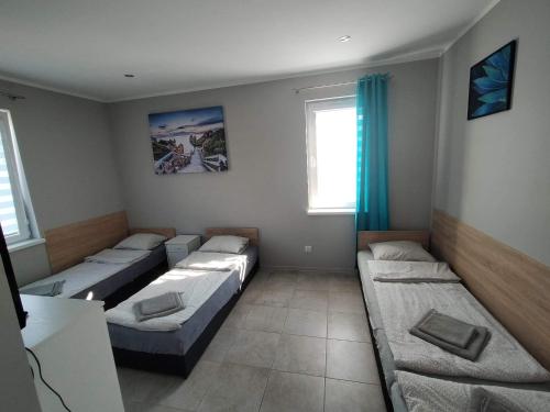 ソレツ・クヤフスキにあるDomki całoroczne Panameraのベッド4台と窓が備わる客室です。