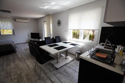 Il comprend une cuisine et un salon avec une table et un canapé. dans l'établissement Apartment Azulmburgo, à Vrnjačka Banja