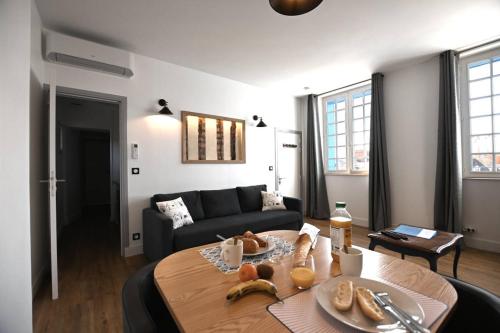 - un salon avec un canapé et une table avec de la nourriture dans l'établissement Villa Normande, à Lisieux