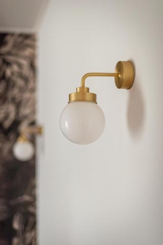 a light hanging on a wall in a room at Chateau des Ayes - Chambres & suites in Saint-Étienne-de-Saint-Geoirs