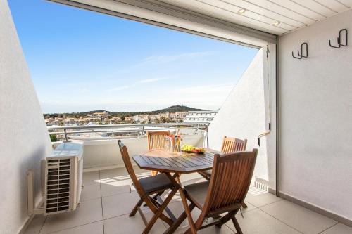 une table et des chaises sur un balcon avec vue dans l'établissement Le Nude - Port Ambonne Village Naturiste, au Cap d'Agde