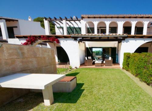 a white bench in the yard of a house at Orquidea in Perelló