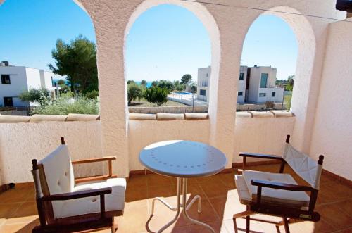 a patio with a table and chairs and windows at Orquidea in Perelló