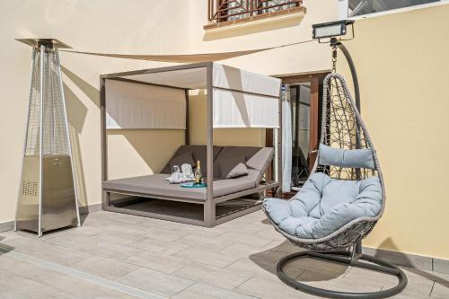 una silla mecedora en un patio con cama en Villa Beatrice en Playa Blanca