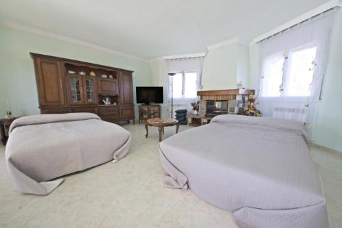 a large bedroom with two beds and a television at Villa Nicole in L'Ampolla