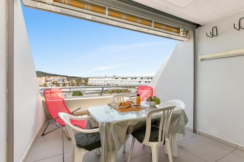 une salle à manger avec une table et des chaises sur un balcon dans l'établissement Le CRISTAL Port Ambonne Village Naturiste, au Cap d'Agde