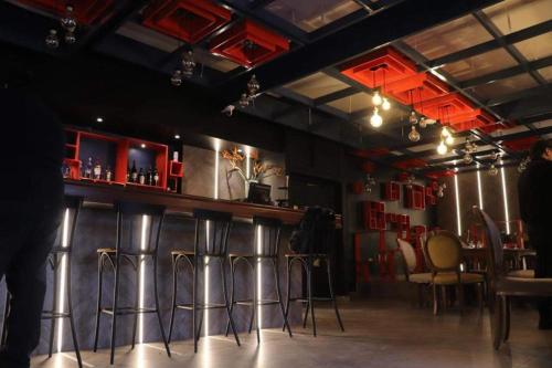 a bar with stools in a room with red at Hotel La Residence Hammamet in Hammamet