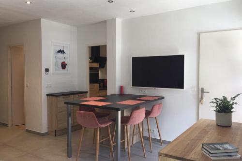 une salle à manger avec une table et des chaises roses dans l'établissement Modern Flat In The Heart Of Chamonix, à Chamonix-Mont-Blanc