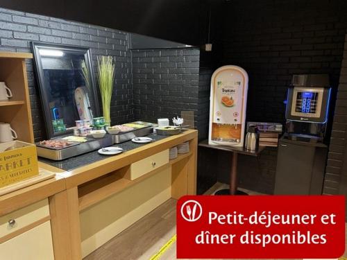 a restaurant with a counter with food on it at Hôtel inn design Sancé in Mâcon
