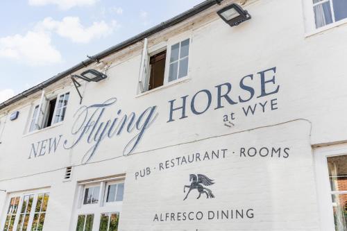 a white building with a sign that reads flying horse at wvg at New Flying Horse Inn in Wye