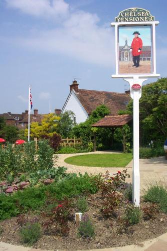 a sign in a garden with a picture of a man at New Flying Horse Inn in Wye