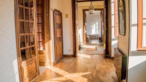 um corredor com pisos e portas de madeira e um quarto com um corredor em Maison Pierre Loti, gîte historique et spacieux en vallée de la Dordogne em Bretenoux