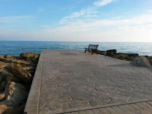 a bench sitting on a pier near the ocean at Hotel Miramare Garzia in Marinella di Selinunte