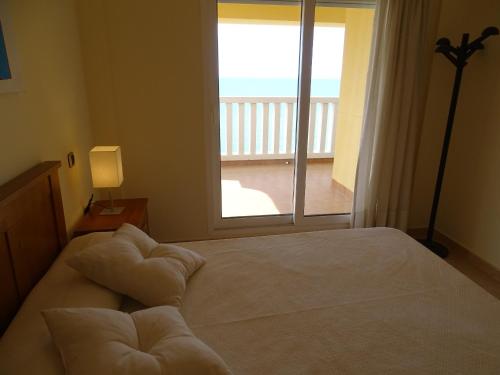 - une chambre avec un lit et un balcon dans l'établissement Dos Mares Admer 01, à La Manga del Mar Meno