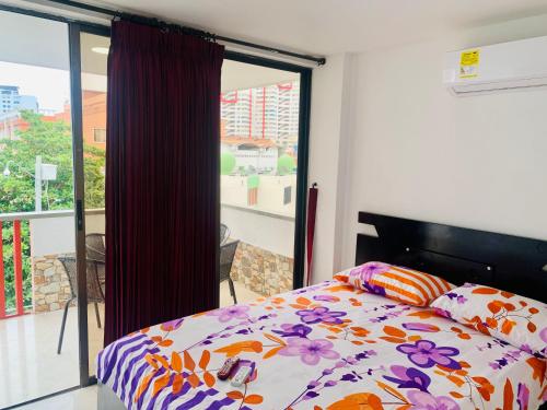 a bedroom with a bed and a balcony at Santa Marta Apartamentos Salazar - Caribe in Santa Marta