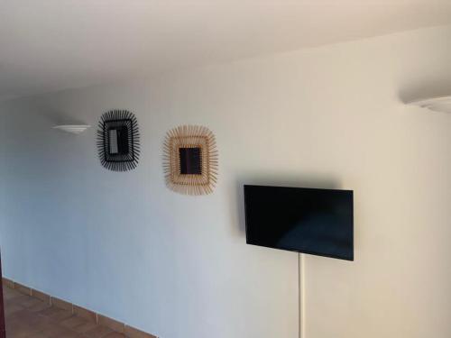 2 Spiegel an einer Wand mit einem TV in der Unterkunft RÉSIDENCE DE LA BAIE Sunshine TARTANE in La Trinité