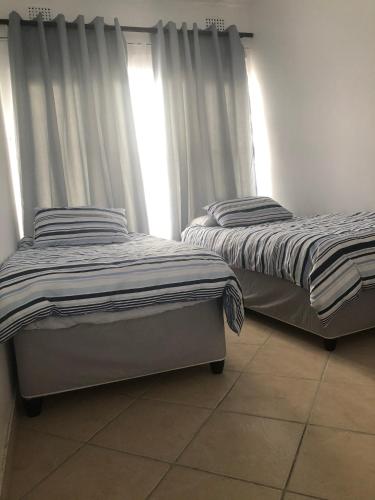 two beds sitting next to each other in a room at Apartment with a Seaview- Amanzimtoti in Amanzimtoti
