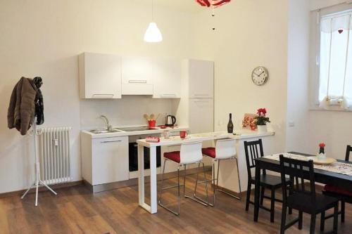 una cucina con armadi bianchi, tavolo e sedie di Trastevere Sweet Home a Roma