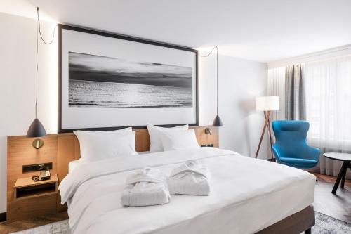 a bedroom with a large white bed with towels on it at MERCURE KLAIPEDA CITY HOTEL, Meetings, Events, Restaurant & Bar - Accor Group, Pet Stay FREE in Klaipėda