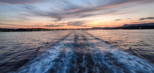 a boat on the water at sunset at ΑRILLA STUDIOS in Perdika