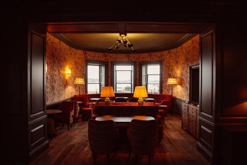 a room with red chairs and a table and lamps at Glasson Lakehouse in Athlone