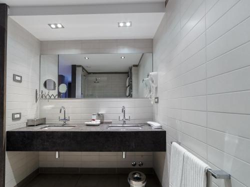 a bathroom with two sinks and a large mirror at Hotel Mirasole International in Gaeta
