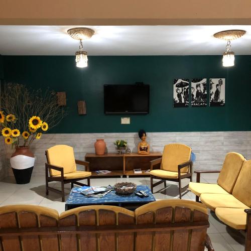 a living room with a couch and chairs and a tv at Pousada Serra Negra in Bezerros