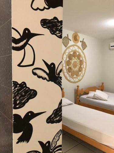 a bedroom with black birds on the wall at Pousada Serra Negra in Bezerros