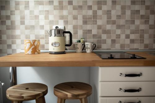 a kitchen counter with a coffee maker and two stools at ALBERT RESIDENCE Aparthotel in Braşov