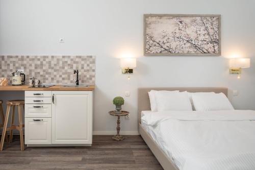 a bedroom with a white bed and a sink at ALBERT RESIDENCE Aparthotel in Braşov